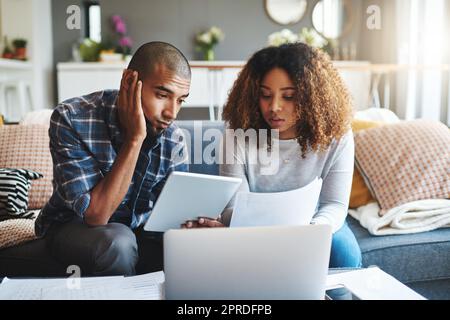 Stressed, worried and anxious couple doing finances, budget and internet banking. Upset couple looking at savings and online investment. Man and woman struggling with debt, loan and bond payment Stock Photo