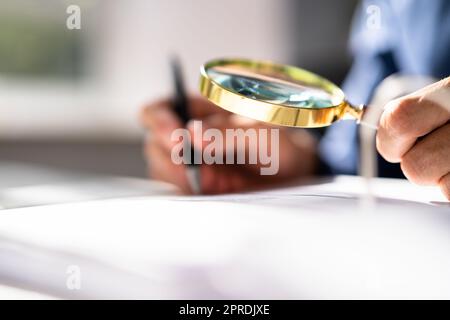 Corporate Auditor Using Magnifying Glass Stock Photo