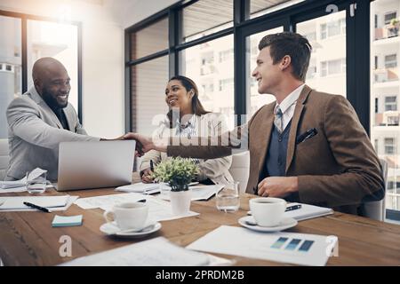 Winning deals is what they do. young businessmen shaking hands during a meeting in a modern office. Stock Photo