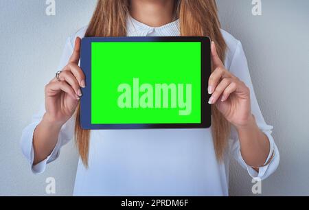 Enter your caption right here. an unrecognizable woman holding a digital tablet against a blue background. Stock Photo