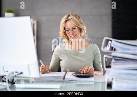 Accountant With Folders Paper Stack Doing Invoice Stock Photo