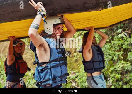 All good things are free and wild. a group of friends on their way to the river with a raft. Stock Photo