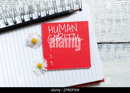 Text caption presenting Human Capital. Word Written on Intangible Collective Resources Competence Capital Education Sticky Note With New Ideas Over Notebook With Pencil And Flowers Around. Stock Photo