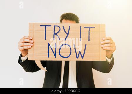 Text caption presenting Try It Now. Internet Concept Free trial of something new experiment different things Businessman Holding Speech Bubble With Important Informations. Stock Photo