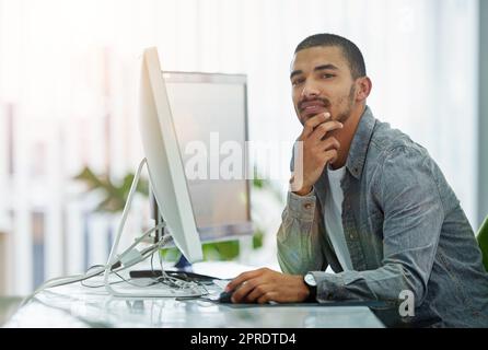Trendy businessman, IT or software engineer with good innovation and web development design development idea at tech company. Face portrait of a young ux or ui designer with a modern desktop computer Stock Photo