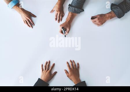Business people writing on white paper in meeting, planning a marketing strategy and writing creative ideas together from above. Top view of hands of team of designers drawing a design on blank page Stock Photo