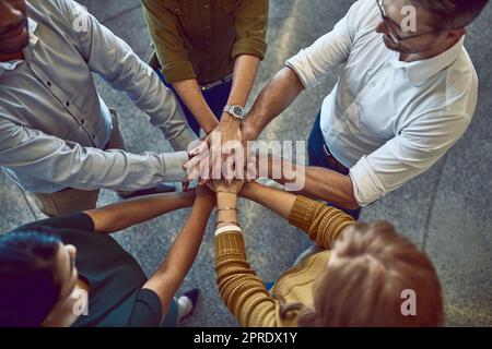 Successful, celebrating and winning colleagues stack hands in unity, support and trust during team building. A group of cheerful business people putting palms together enjoying success in the office Stock Photo