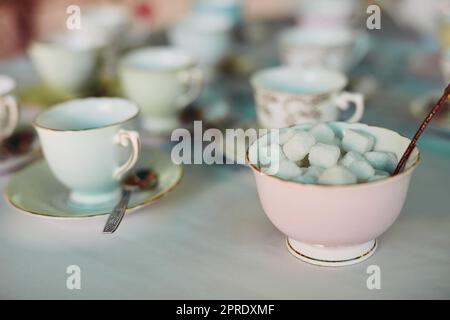 Its all about how many cubes you take with tea. Closeup shot of tea cups laid out on a table at a tea party inside. Stock Photo