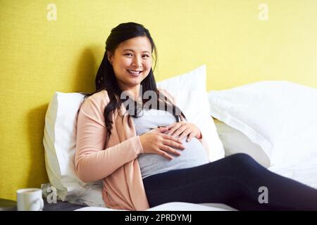 Mommy needs to relax while she can. Portrait of a pregnant woman relaxing at home. Stock Photo
