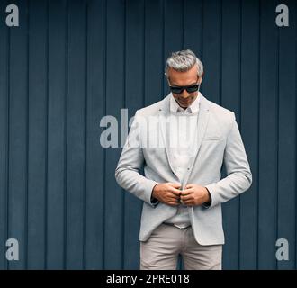 Looking suave and sophisticated. a smartly dressed mature businessman standing outside. Stock Photo