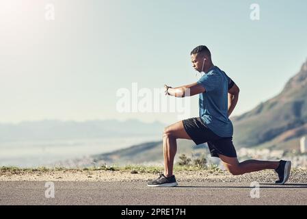 Timing his lunges. a young handsome man doing lunges outdoors. Stock Photo