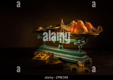 Organic pears on old vintage scales with brass weights on wooden background Stock Photo