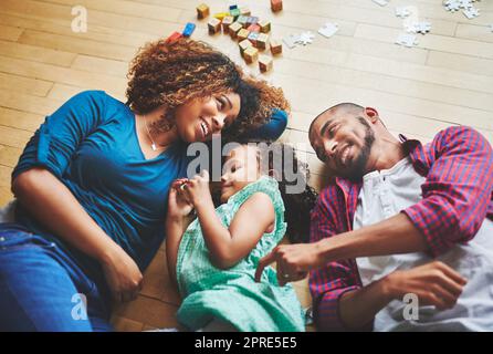 Nothing beats the giggles and the cuddles. a family of three spending quality time together. Stock Photo