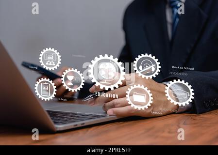 Businessman using laptop computer icon virtual screen education online and e learning on desk. Stock Photo