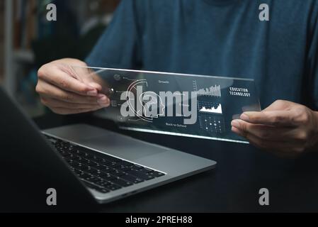 Businessman using laptop computer icon virtual screen education online and e learning on desk. Stock Photo