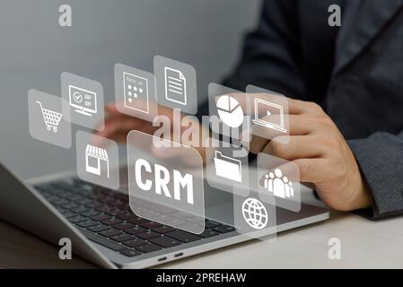 Hand typing on laptop concept. Icons CRM Customer Relationship Management business on virtual screen. Stock Photo