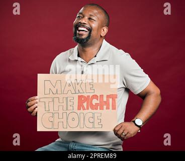 African american covid vaccinated man showing and holding poster. Smiling black man isolated against red studio background with copyspace. Happy model Stock Photo