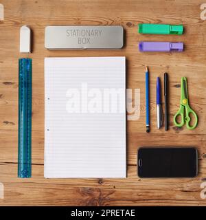 School supplies, stationary or equipment for young working and studying students top view. Assortment, variety or array of education essentials items including a phone and notebook on a wooden desk Stock Photo