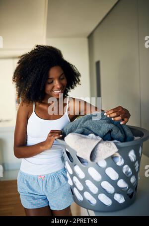 This will be sorted and then washed. an attractive young woman doing the laundry at home. Stock Photo