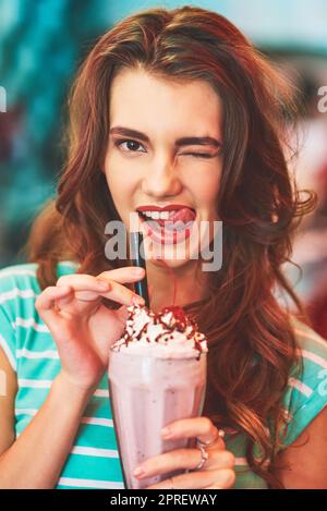 Mmmm now that was a yummy milkshake. a beautiful young woman drinking a milkshake in a diner. Stock Photo