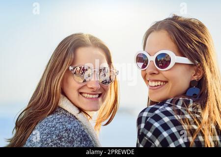 This is what happiness looks like. Rearview portrait of two attractive young women spending a day by the ocean. Stock Photo