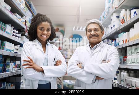 They are knowledgeable, friendly and professional. Cropped portrait of two pharmacists standing together with their arms crossed in a pharmacy. Stock Photo
