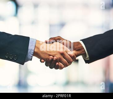 Its a done deal. Closeup shot of two unrecognizable businessmen shaking hands in an office. Stock Photo