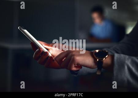 Completing my work quickly with my device. an unrecognizable businesswoman using a tablet while working late at night in the office. Stock Photo