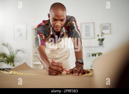 . Fashion designer, pattern making and sewing template with stylist planning, drawing and measuring for costume design. Male creative in textile factory, clothing workshop and manufacturing studio. Stock Photo