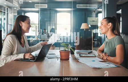 Job interview for a business woman at a hiring company talking to the HR manager about the role or position. Young female applicant or candidate in a meeting with an employer having a discussion Stock Photo