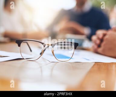 Focus on your vision. a pair of reading glasses on a table in the office. Stock Photo