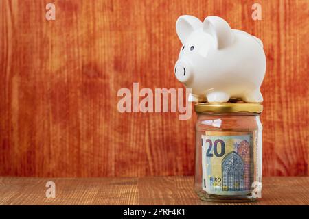 Piggy bank and glass jar with euros for saving emergency money Stock Photo