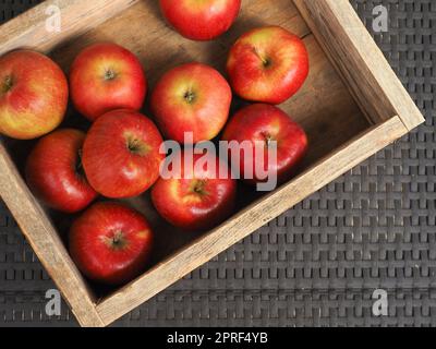 Fresh red organic apples in a wooden box after harvesting Stock Photo
