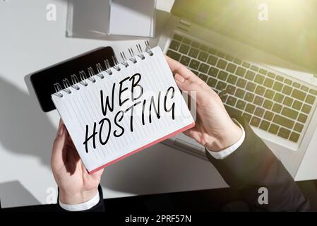 Text caption presenting Web Hosting. Business showcase The activity of providing storage space and access for websites Businesswoman Holding Notebook Over Desk With Notes, Cellphone And Lap Top. Stock Photo