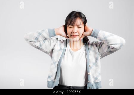 Woman bad mood pain her closed ears with hand palms and close eyes Stock Photo