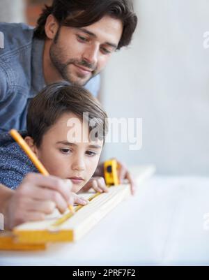 DIY is a precise business. A father and son doing woodwork together Stock Photo