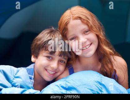 Making camping look cute. Portrait of a young brother and sister sitting inside their tent Stock Photo