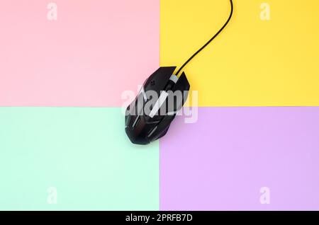 Optical gaming mouse is located between areas of different colors. Device for cybersport and online video games. Flat lay minimal. Top view Stock Photo