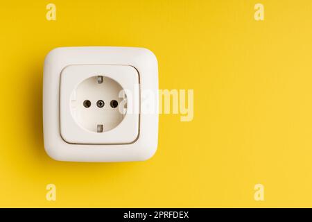 Wall socket on yellow wall. Stock Photo