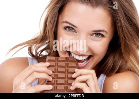 I cant only have one bite. An attractive young woman eating a slab of chocolate Stock Photo