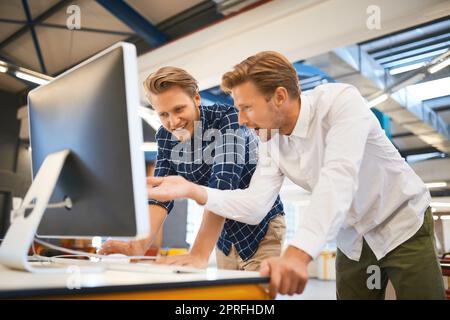 Theyre two of the very best. two young male designers working on a desktop in their office. Stock Photo