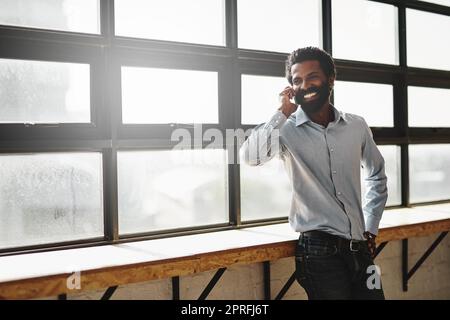 Im glad youre happy with our services...a businessman talking on a cellphone in an office. Stock Photo