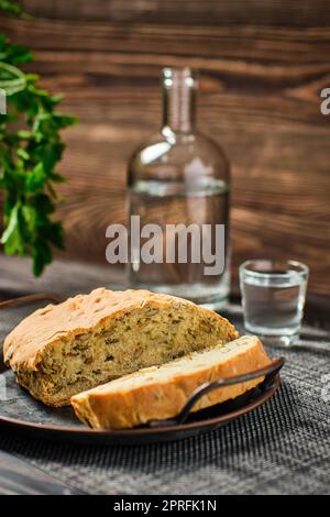 Homemade bread with pumpkin seeds and frozen vodka on rustic background Stock Photo