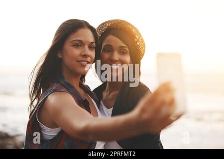 Beaching with my bestie. two young friends taking a selfie together at the beach. Stock Photo