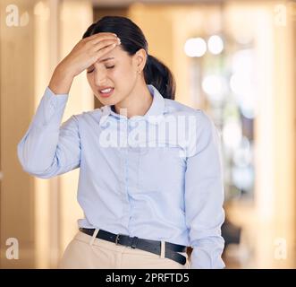 Stress, sick and tired business woman with a headache feeling sad and unhappy at work. Young female employee or worker suffering from a migraine and is depressed, overworked and burnout Stock Photo