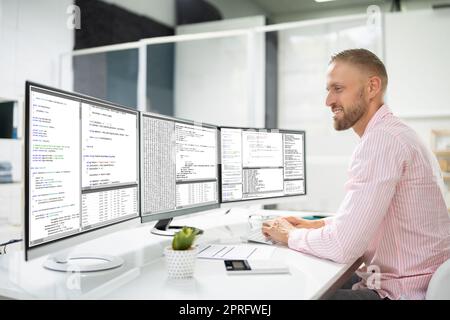 Computer Programmer Writing Program Code On Computer Stock Photo