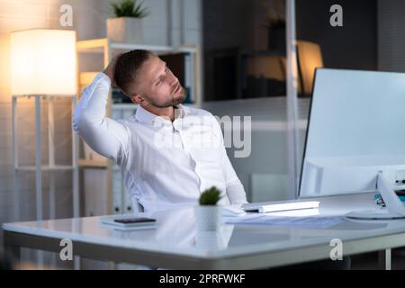 Man Stretching At Office Desk Stock Photo