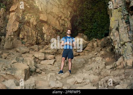 Its the perfect spot to capture some shots. a young man taking photos while out on a hike. Stock Photo