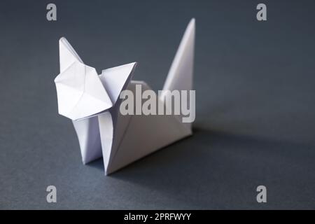 White paper cat origami isolated on a grey background Stock Photo