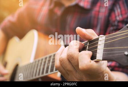 Musician playing acoustic guitar. Close up of man hand playing guitar. Stock Photo